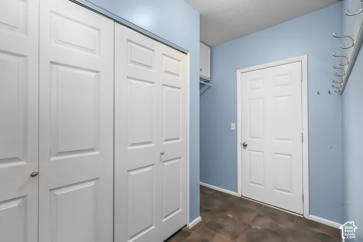 Bifold paneled doors, light blue wall paint, white trim, coat hooks, and durable flooring