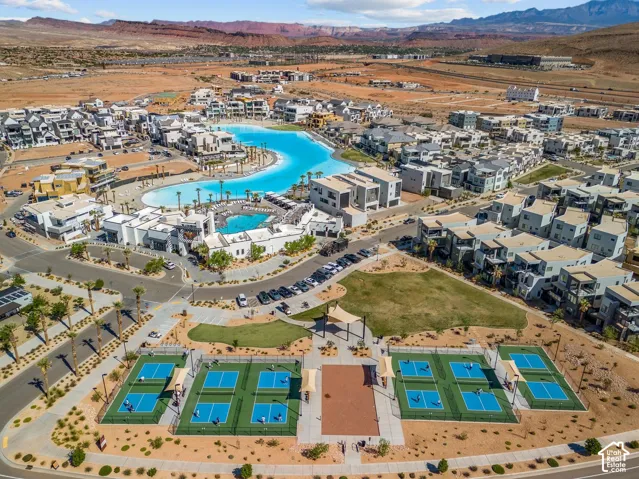 Expansive community featuring a large recreational lagoon, multiple residential structures, a dedicated recreational building, and several pickleball courts