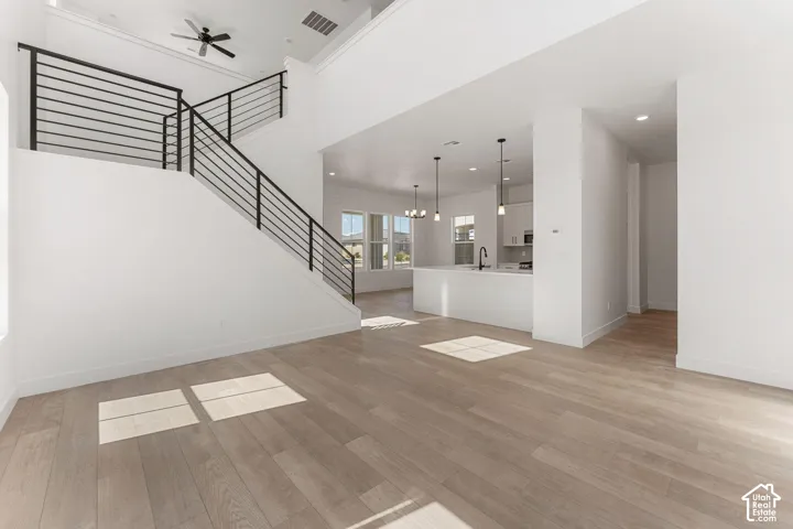 Open-concept living space featuring wood-finish flooring and a two-story ceiling