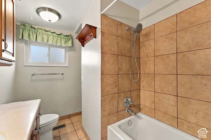 Bathroom featuring a white bathtub, ceramic tile walls, and a window for natural light