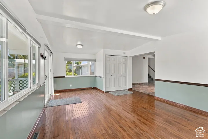 Hardwood flooring throughout, multiple windows, sliding glass door access, recessed lighting, and a bi-fold closet