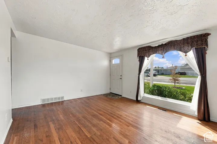 Hardwood-finish flooring, white walls, and a large picture window