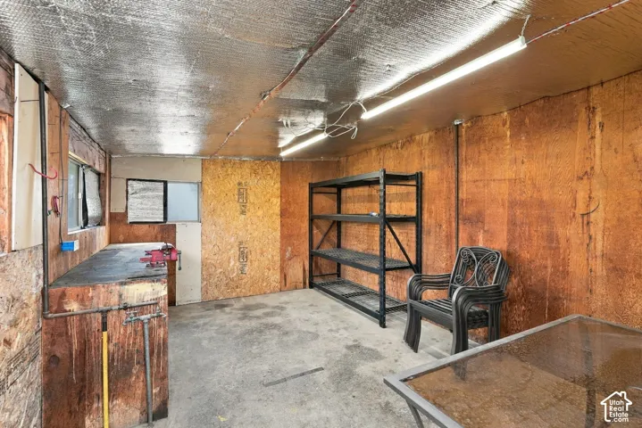 Insulated ceiling with exposed wood-finish walls, a built-in workbench, and multiple windows