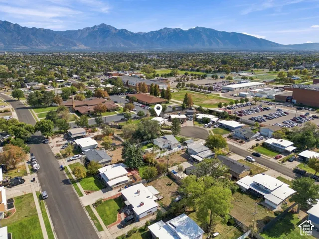 Residential street with established trees, distant mountain range, and surrounding community