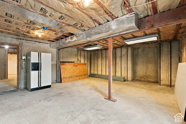Concrete flooring, exposed ceiling joists, and fluorescent lighting fixtures
