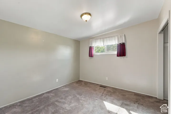 Recessed window with exterior scenery, overhead flush mount light fixture, and wall-to-wall carpeting