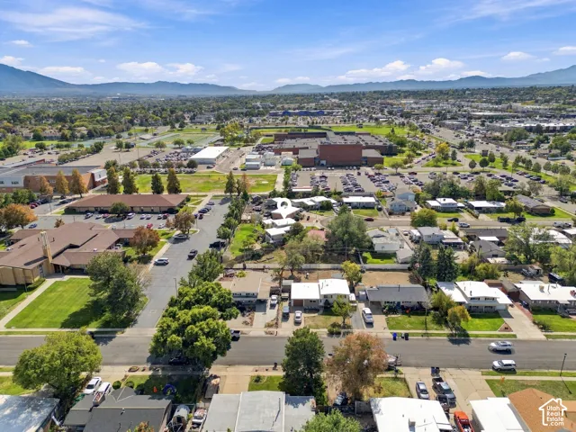 Expansive suburban landscape with distant mountain ranges and scattered commercial buildings
