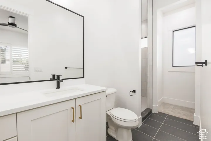 White vanity with gold-tone hardware, a rectangular undermount sink, and a matte black faucet