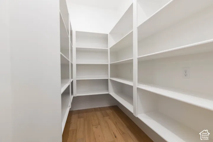 Built-in shelving, wood-finish flooring, and white painted walls