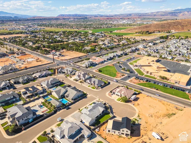 Aerial perspective showcasing a developed residential area with numerous single-family homes, some featuring private swimming pools