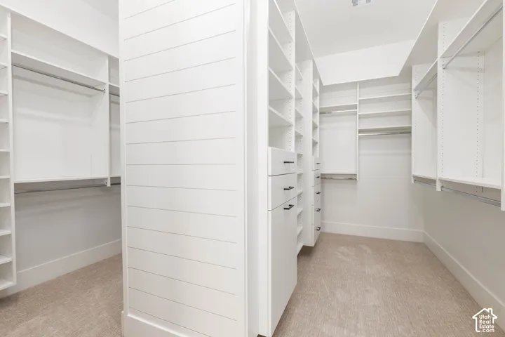 Custom closet system with multiple shelving units, integrated drawers with dark hardware, and ample hanging rods