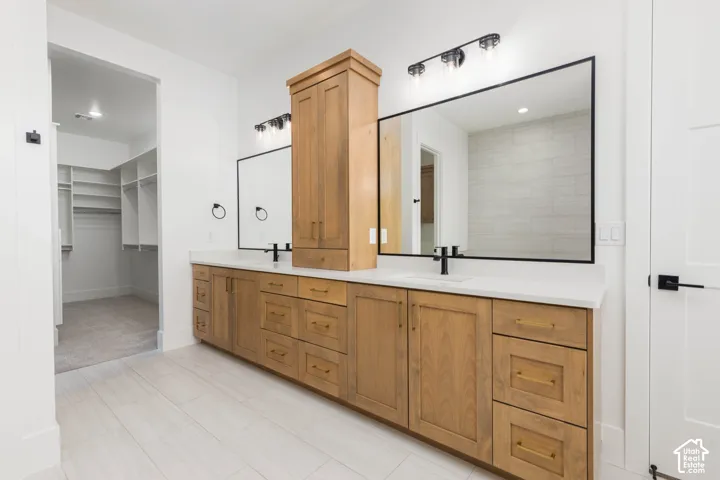Dual vanity with wood-finish cabinetry, integrated sinks, and matte black fixtures