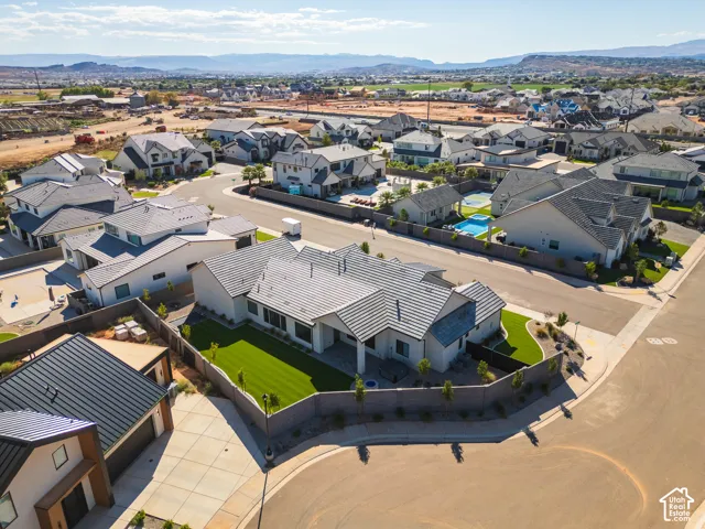 Contemporary residential architecture with a tiled roof and expansive paved driveway