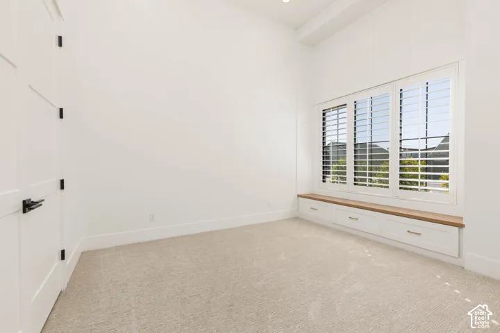 Built-in window bench with wood-finish top, white cabinetry, and gold-tone hardware
