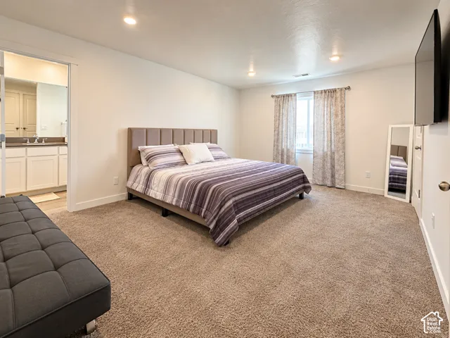 Plush carpeting, recessed lighting, and a window with curtains