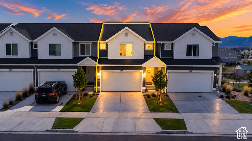 Contemporary exterior with contrasting siding, gabled rooflines, an attached garage, a paved driveway, and mature landscaping