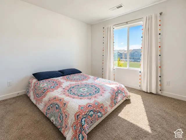 Carpeted room featuring white walls and a large window