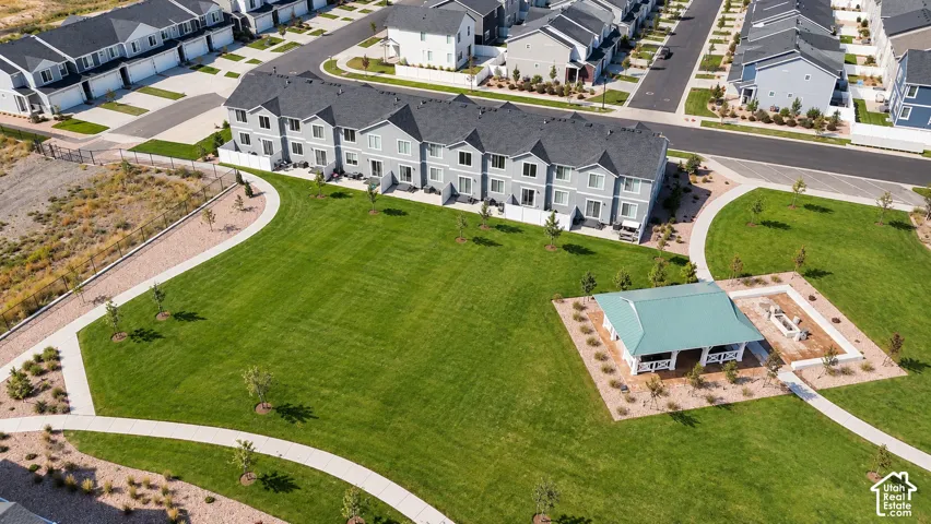 Townhome community with a large green space, a white gazebo with a green roof, and walking paths