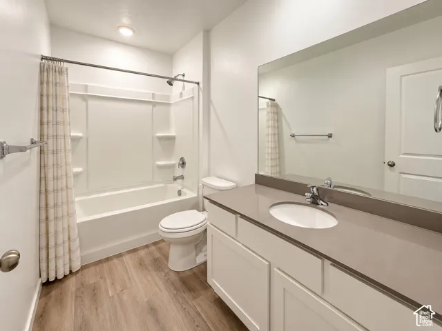Bathroom featuring a large vanity with an integrated sink, polished chrome faucet, and expansive mirror