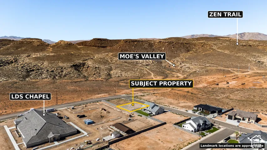Aerial perspective featuring a desert landscape with distant mountains, a residential area with single-family homes, and paved roads