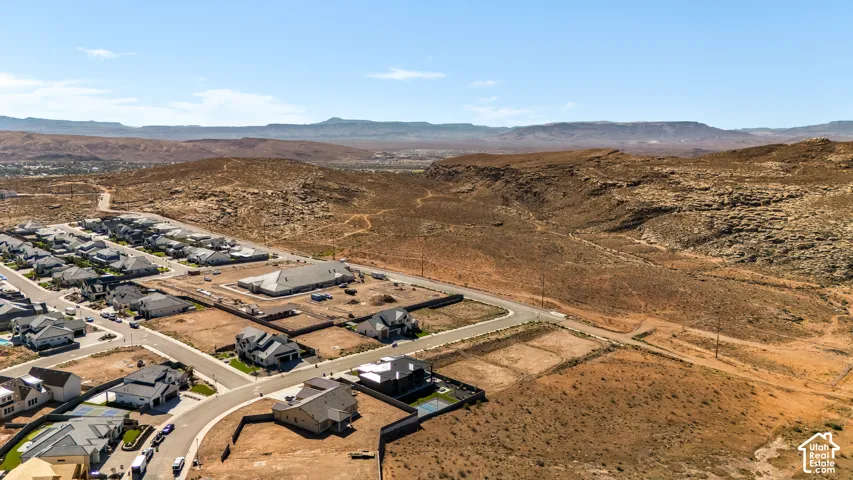Developing residential community with paved roads, surrounded by arid landscape and distant mountains
