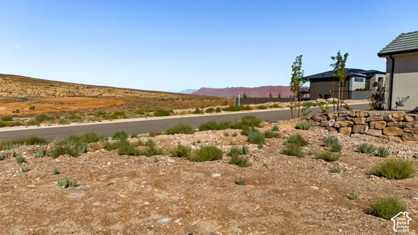 Property featuring a stone retaining wall and desert landscaping