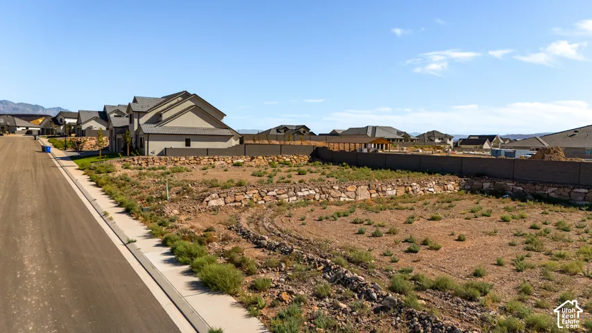 Expansive lot with stone retaining walls, surrounded by existing residential structures