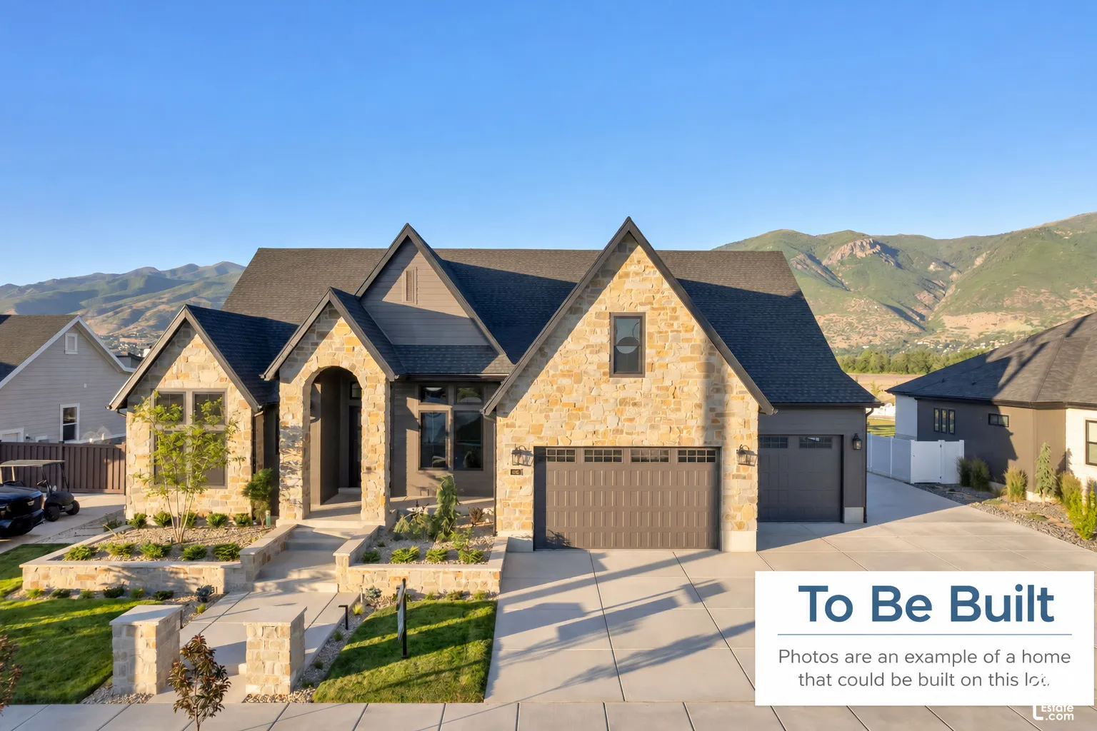Stone and siding exterior featuring a multi-gabled roofline, an arched entryway, three-car garage, and mountain backdrop