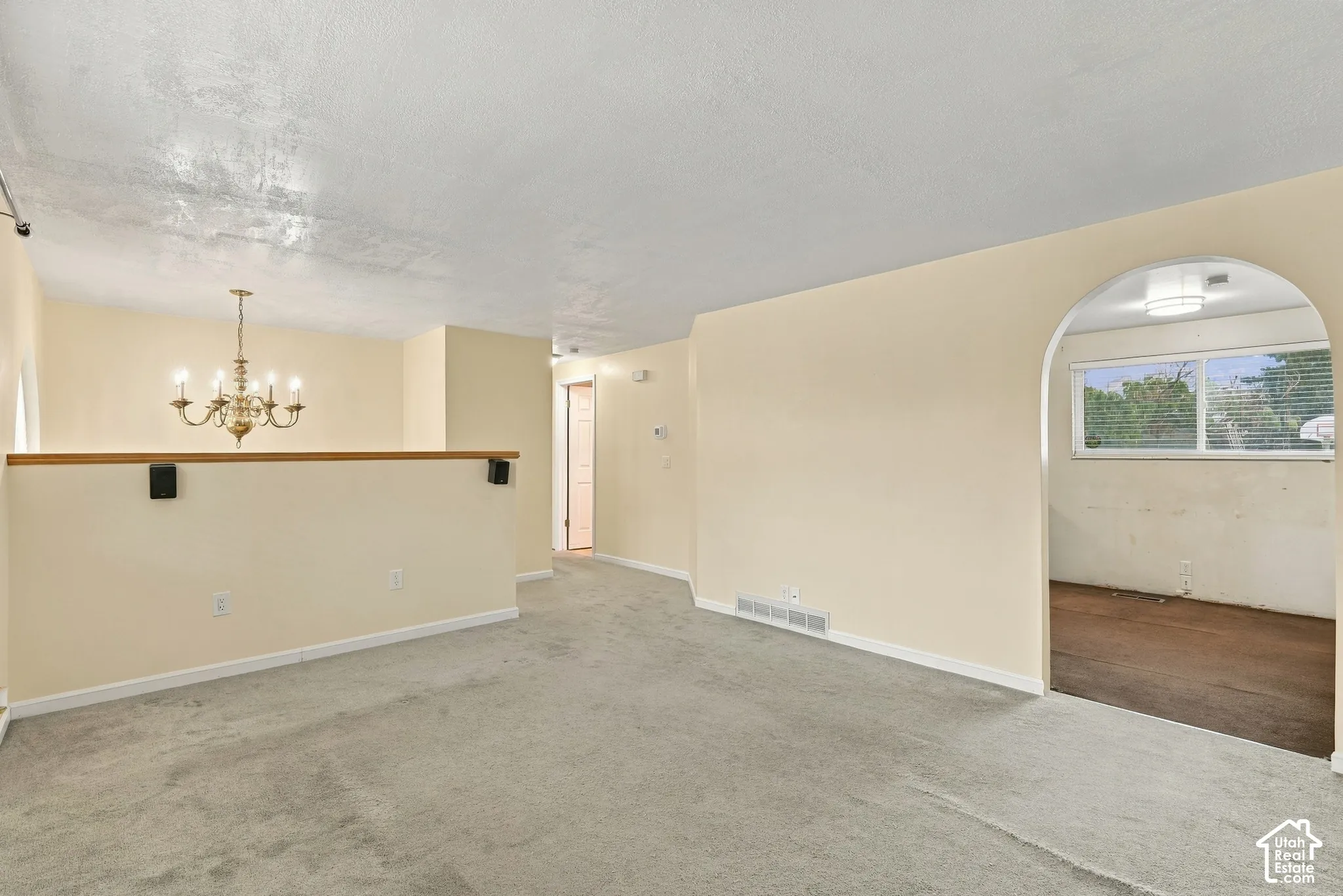 Archway entry, brass chandelier, and light-colored walls