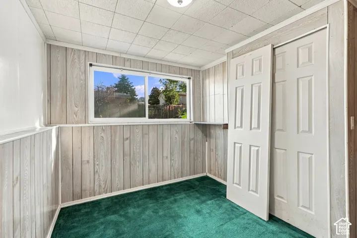Wood-paneled walls with coordinating trim, a window, and two closet doors