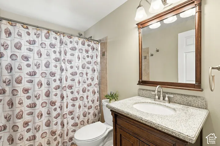 Vanity with a light-toned countertop, undermount sink, and wood-finish cabinetry