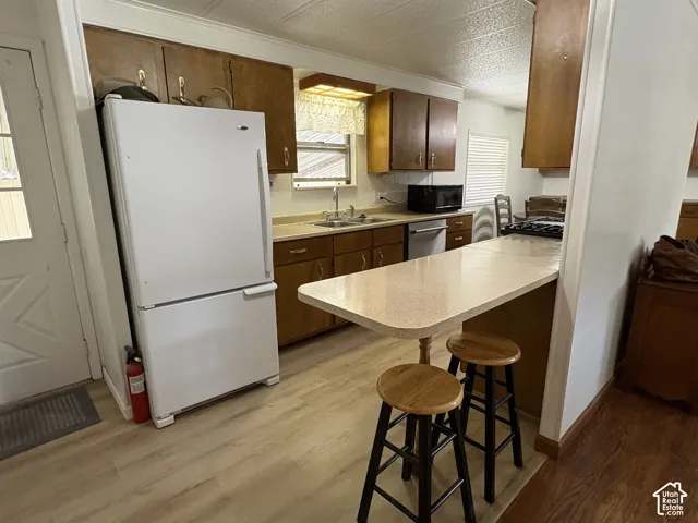 Kitchen featuring wood-finish flooring, built-in cabinetry, and a breakfast bar