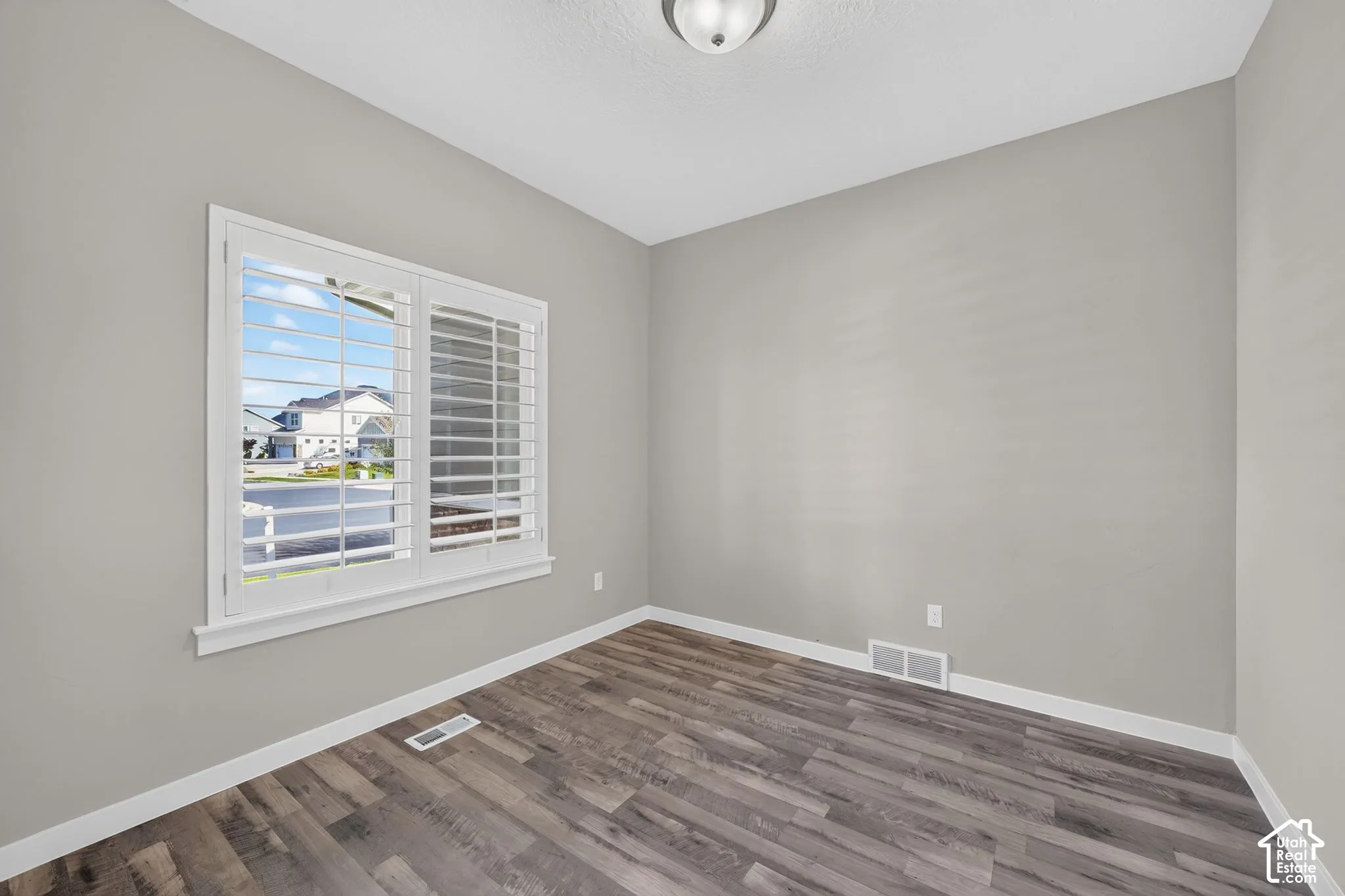 Wood-finish flooring, light grey wall paint, and white trim