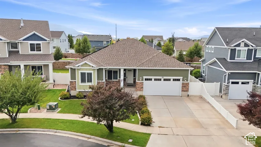 Single-story residence featuring a two-car garage, stone accents, and a covered entry