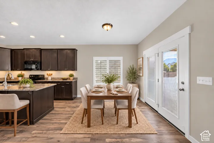 Kitchen with dark wood cabinetry, light-toned countertops, and wood-finish flooring