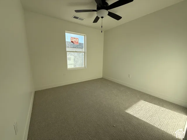 Neutral wall tones, recessed window, ceiling fan with integrated lighting, and carpeted flooring