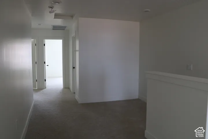 Recessed ceiling lighting, light gray wall finishes, light gray carpeting, white trim, and white doors