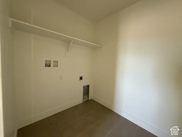 White wall shelving, tile flooring, and appliance hookups