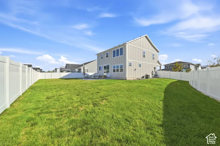 Expansive lawn area with a white privacy fence