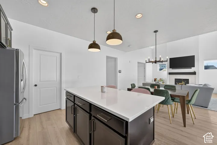Kitchen island featuring a white quartz countertop and dark cabinetry