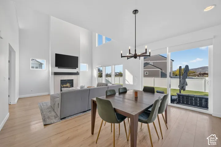 Two-story living area with fireplace, wood-finish flooring, and large sliding glass doors