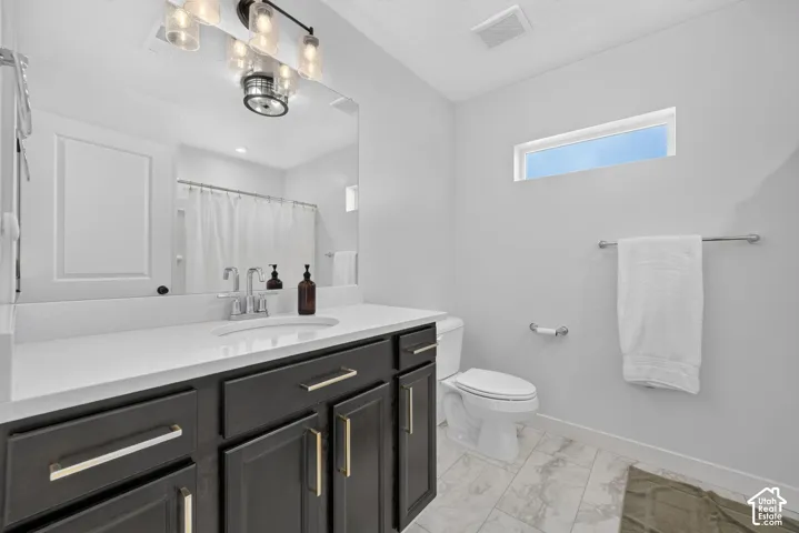 Bathroom #2 upstairs featuring a dark wood-finish vanity and a white quartz countertop