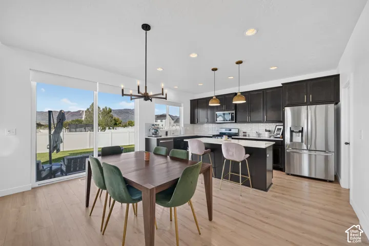 Kitchen featuring dark cabinetry, stainless steel appliances, a white subway tile backsplash, and an island with a white quartz countertop
