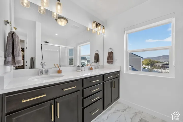Primary bathroom featuring a dual vanity with white countertops and dark cabinetry