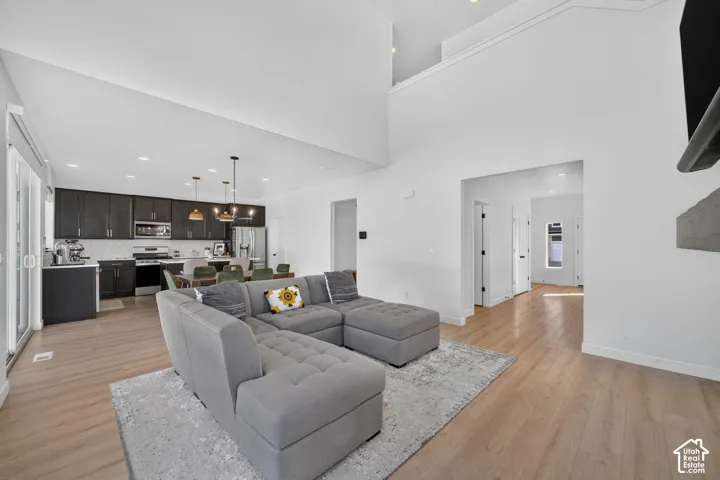 Vaulted ceilings, wood-finish flooring, dark wood cabinetry, stainless steel appliances, and sliding glass doors