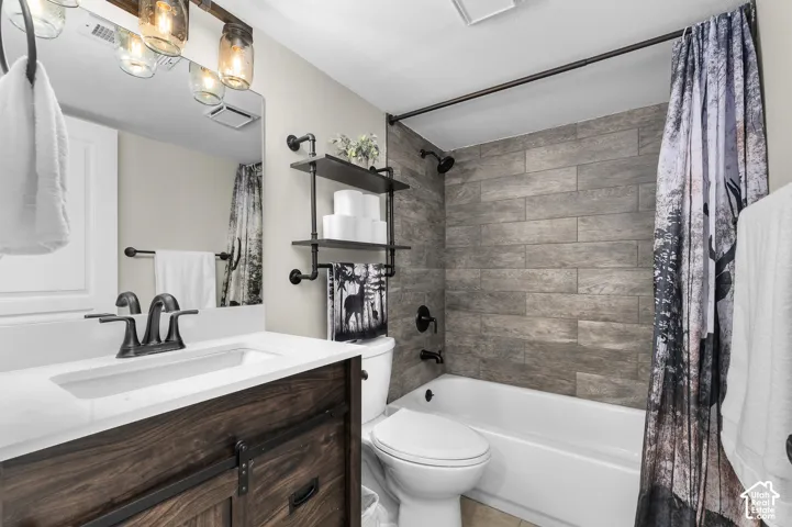 Wood-finish vanity with a white countertop and dark bronze faucet, accompanied by a rectangular mirror