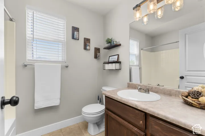 Bathroom featuring a single vanity with an integrated sink, built-in mirror, and a wall-mounted light fixture