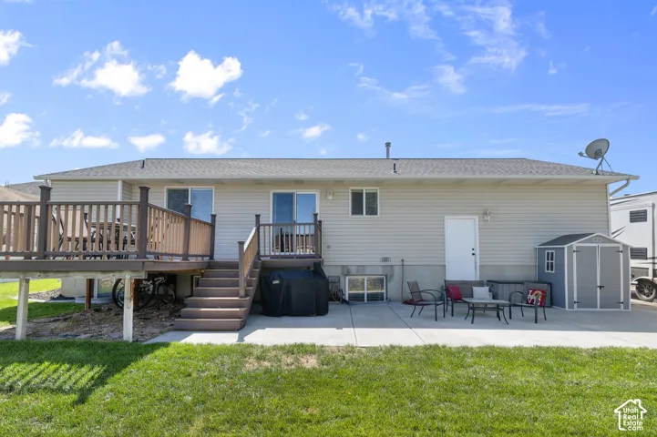Expansive backyard featuring a multi-level deck, concrete patio, and direct access to the interior