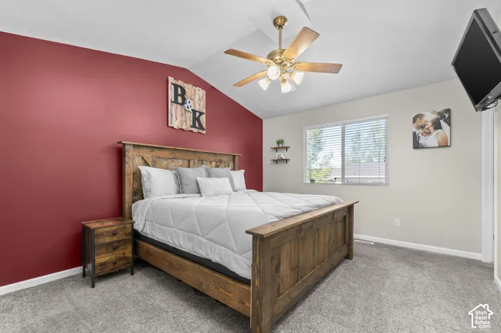 Vaulted ceiling with a brass-finish ceiling fan and light fixture