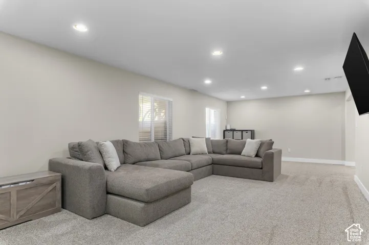 Recessed ceiling lighting, light neutral wall finishes, light gray carpeting, window with blinds